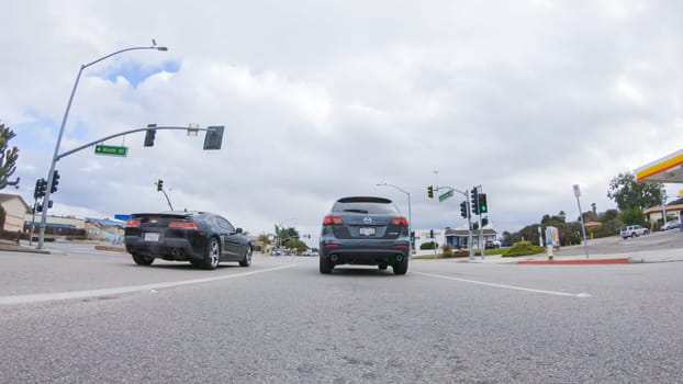 Santa Maria, California, USA-December 6, 2022-Vehicle navigates the streets of Morro Bay, California, during a cloudy winter day. The atmosphere is moody and serene as the overcast sky casts a soft light on the charming buildings and quiet streets of this coastal town.