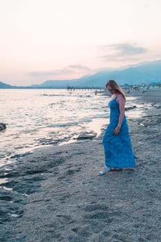 Woman sits on the beach and looks at the sea in Alanya city, Turkey. Travelling or vacation concept