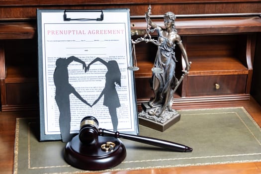 A prenuptial agreement with a silhouette of a couple on a clipboard, with the statue of justice in the background, representing the legalities of marriage