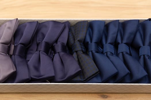 Showcase in a store with beautiful multi-colored bow ties. Many bright colorful beautiful bow ties in an box.
