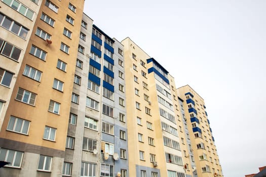 Windows of a multi-storey tall building against the background of the sky