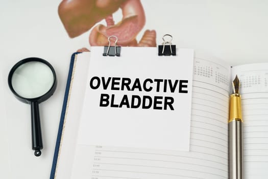 Medical concept. On the table there is a magnifying glass and a notepad with the inscription - Overactive bladder