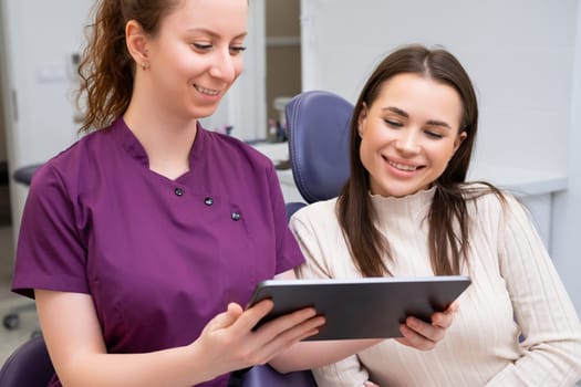 Dentist engages the patient in a conversation about treatment strategies while displaying image on a tablet.