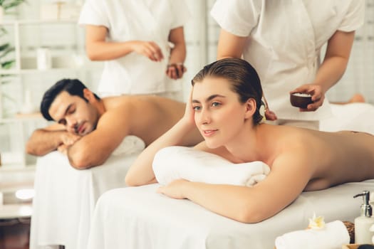 Woman customer having exfoliation treatment in luxury spa salon with warmth candle light ambient. Salt scrub beauty treatment in health spa body scrub. Quiescent
