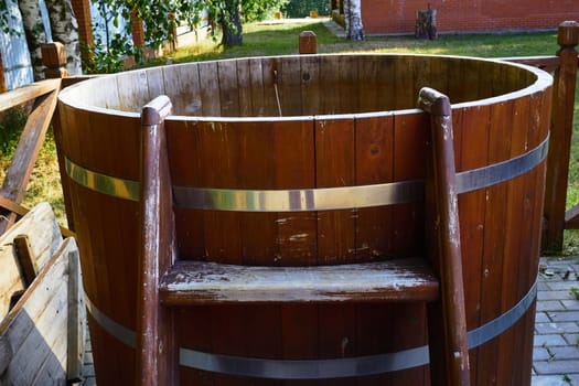 Photo of a wooden baptismal with water on the street. Vacation in the country. Healthy lifestyle. Bath procedures.