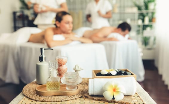 Aromatherapy massage on daylight ambiance or spa salon composition setup with focus decor and spa accessories on blur woman enjoying blissful aroma spa massage in resort or hotel background. Quiescent