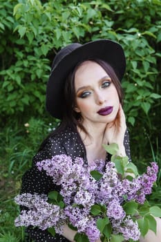 A fashionable girl with dark hair, a spring portrait in lilac tones in summer. Bright professional makeup