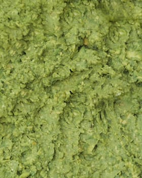 Close view of guacamole, highlighting its creamy texture and fresh green color with visible seasoning
