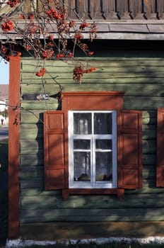 Charming wooden house with vintage window, rustic architecture, and countryside allure. Nostalgic symbol of simpler life, surrounded by natures beauty. Perfect for rustic charm and serene landscapes.