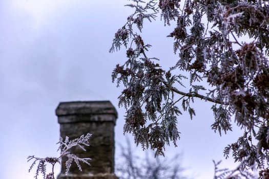 White smoke from the chimney of an old house during frost. Fireplace chimney on an iron roof.