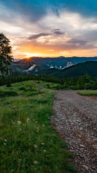 Magical dawn in the Carpathians, in the foreground a road for tourists, fabulous dawns in the mountains.