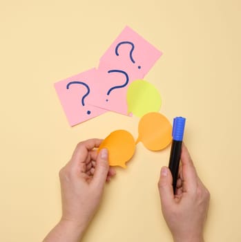 Paper stickers with question marks on a yellow background, searching for an answer