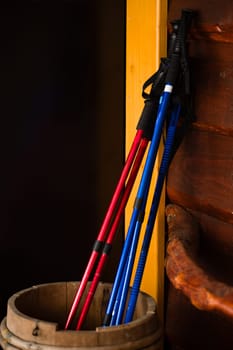 Three pairs of trekking poles are propped up in a barrel, poles for easy walking in the mountains.