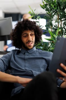 Project manager discussing deadline with coworkers in videocall on digital tablet. Young arab start up entrepreneur talking about strategy with business partner in online meeting