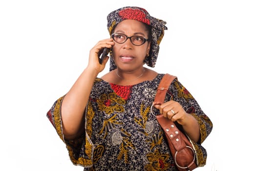 african mature woman in loincloth standing on white background communicating with mobile phone.