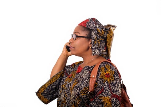 african mature woman in loincloth standing on white background communicating with mobile phone.