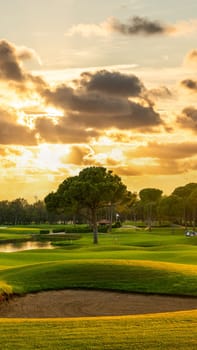 Panorama Golf course with a sand bunker in the center. Dramatic clouds in the sky during sunset