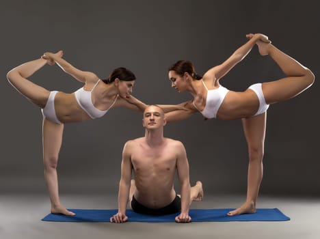 Yoga composition of flexible people posing at camera