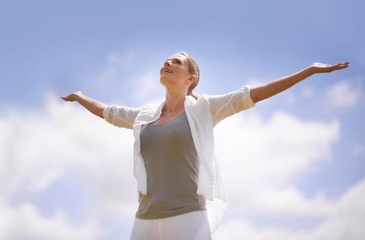 Happy woman, meditation and freedom with blue sky background for spiritual wellness, faith or hope in nature. Calm female person with smile and open arms for fresh air, health and outdoor wellness.