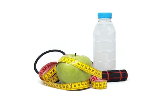 Set of health and fitness-related items with the yoga mat, water bottle behind the apple and measuring tape isolated on white background, healthy living and exercise