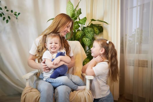 Happy family young mother babysitter relax having fun with cute little children daughters in living room at home