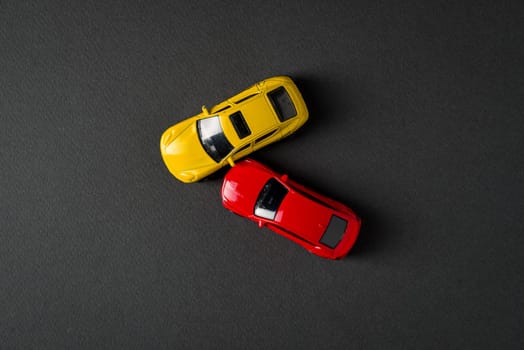 Top view of red and yellow cars colliding and crashing on dark gray background