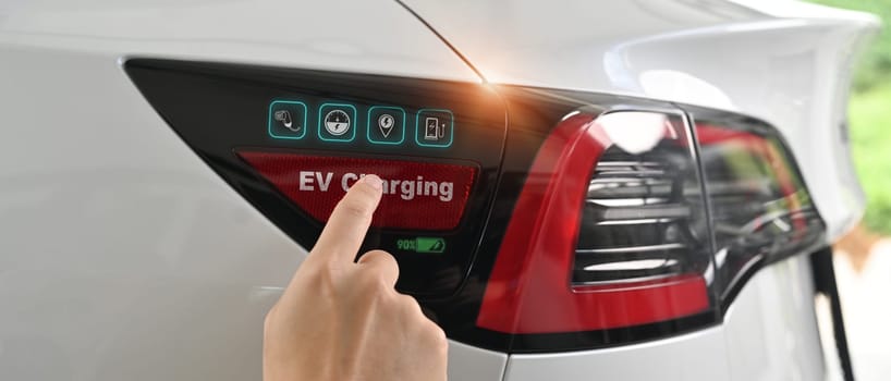 Close up image of man opening a socket cap to preparing to charge an electric vehicle.