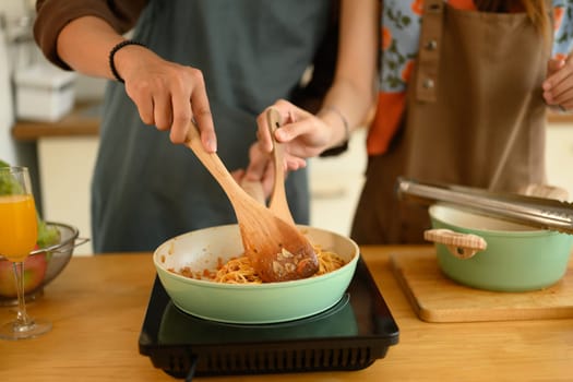 Cropped shot of young couple making delicious bolognese sauce for dinner in kitchen.