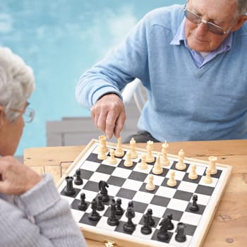 Senior, couple and game of chess outdoor together in retirement with competition of strategy. Thinking, challenge and elderly man and woman with activity or contest on board for holiday or vacation.