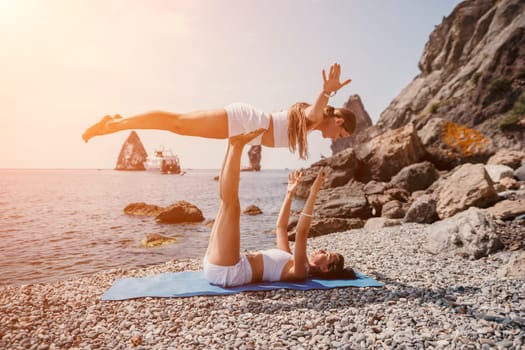 Woman sea yoga. Back view of free calm happy satisfied woman with long hair standing on top rock with yoga position against of sky by the sea. Healthy lifestyle outdoors in nature, fitness concept.