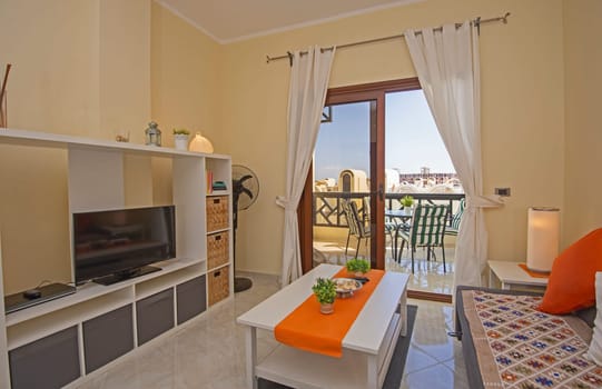 Living room lounge area in luxury apartment show home showing interior design decor furnishing with balcony terrace