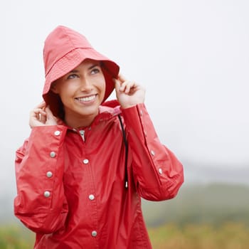 Woman, smile and raincoat for protection, outdoor nature and waterproof jacket for rain or weather. Female person, happy and safety or shield from cold, winter and travel to Scotland for holiday.