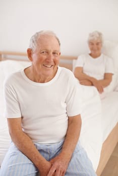 Senior man, couple and portrait in bed, smile and relaxing together in retirement at home. Elderly people, bedroom and happy in marriage or relationship, love and bonding for romance on weekend.