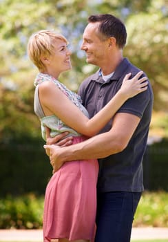 Couple, love and hug with happiness in outdoor for affection, romance and date in Australia. Closeup, relationship and together with smile for bonding, care and trust with commitment for support.