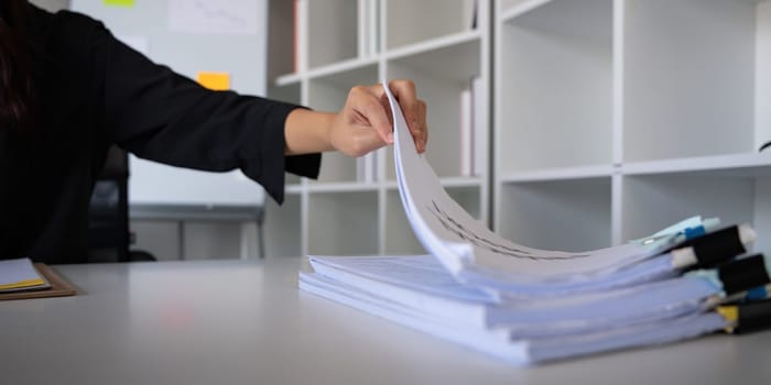 Business accounting woman counting on calculator working on financial document in hands closeup. Bookkeeping concept.