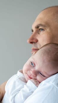 A man holds a baby in his arms. Parental care concept