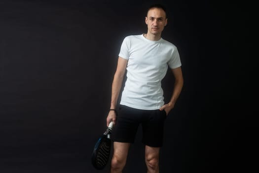 Beautiful man playing paddle tennis, racket in hand concentrated look. Young sporty boy ready for the match. Focused padel athlete ready to receive the ball. Sport, health, youth and leisure concept. High quality photo