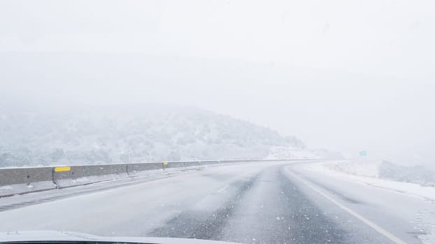 POV-Electric vehicle is captured deftly navigating the I-70 highway during a winter storm in Western Colorado.