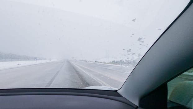 POV-Electric vehicle is captured deftly navigating the I-70 highway during a winter storm in Western Colorado.