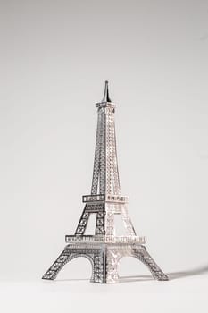 Metal Eiffel Tower cutout on white background. Lattice design highlights skill and precision, creating intricate pattern.