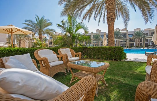 Garden terrace furniture of a luxury apartment in tropical resort with furniture and pool view