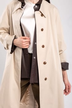 A sophisticated and timeless look for any occasion, this beige trench coat features a sleek and clean design with a hint of luxury.