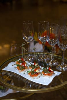 A luxurious catering table is adorned with champagne glasses and delectable appetizers, creating an opulent atmosphere for a special event.