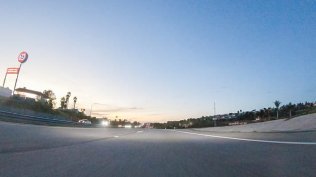 Los Angeles, California, USA-December 4, 2022-POV-As the sun sets, driving on HWY 101 near Pismo Beach, California becomes a captivating experience with the sky painted in shades of orange and pink, casting a warm glow over the coastal landscape.