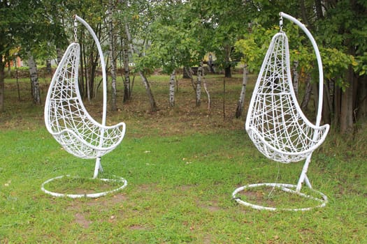 Photo two white hanging chairs. A place to relax. Relaxation.