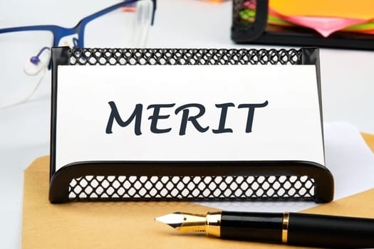 Business and merit concept. MERIT written on a business card on the table