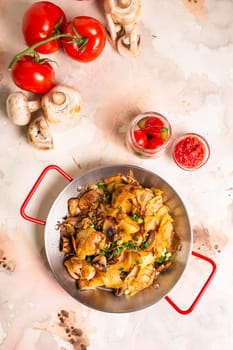 Sliced potatoes, fresh mushrooms, and diced onions sizzling in a frying pan on a clean white background, ready to be cooked.