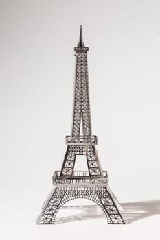 Metal Eiffel Tower cutout on white background. Lattice design highlights skill and precision, creating intricate pattern.