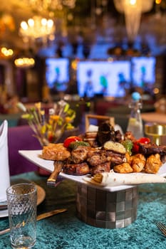 assorted different kebabs on a white plate in a restaurant.