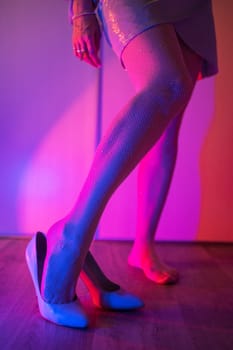 Woman legs closeup in stokings with neon color background